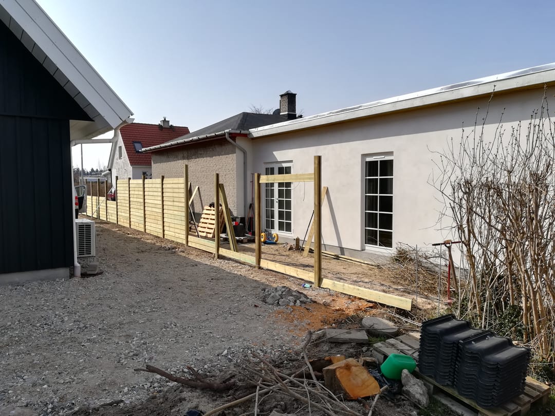 Bygyndende opsætning af brædder på hegn